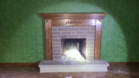 A fireplace in a main room in House 1