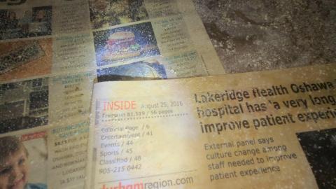 Close up of the newspapers on a shelf inside basement of House 2