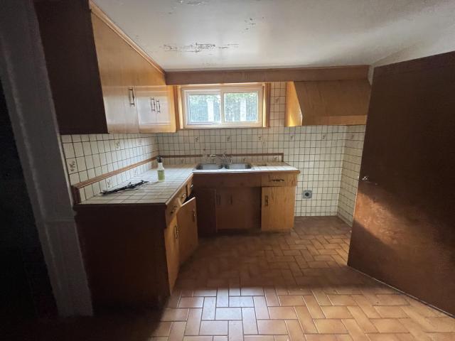 70s bungalow sits in a neighborhood of new mansions photo 3