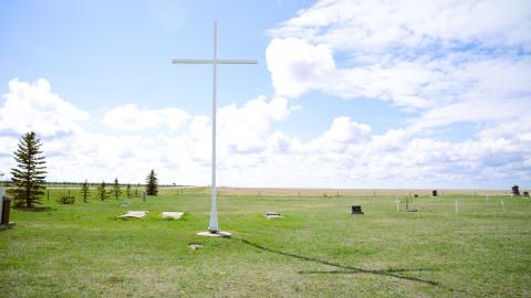 A large white cross in a cemetery