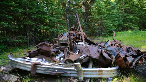 A totally destroyed car located near a mine