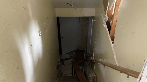 the stairs to the basement. right side of the door frame has broken glass sticking out of it.