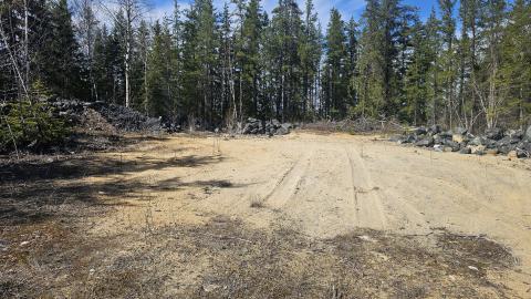 A large open sandy area surrounded by mine rock
