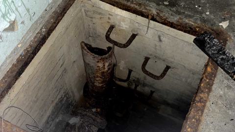 a hole in the floor with a ladder down