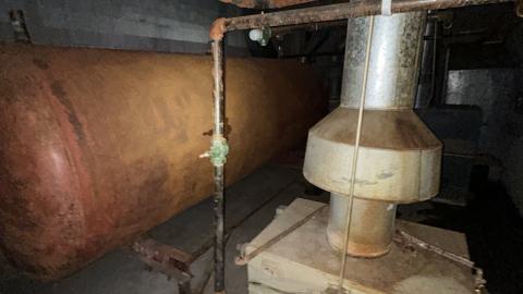 huge gas tank with many danger signs around it