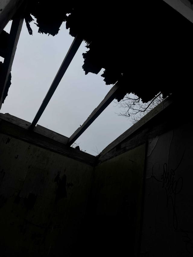a broken roof of an abandoned shed