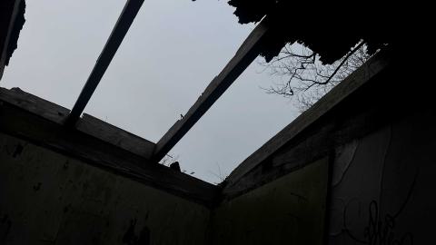 a broken roof of an abandoned shed