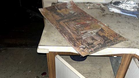 a painting on a kitchen counter in an abandoned house