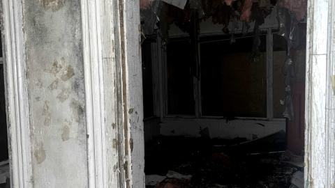 a room in an abandoned house with insulation hanging from the ceiling