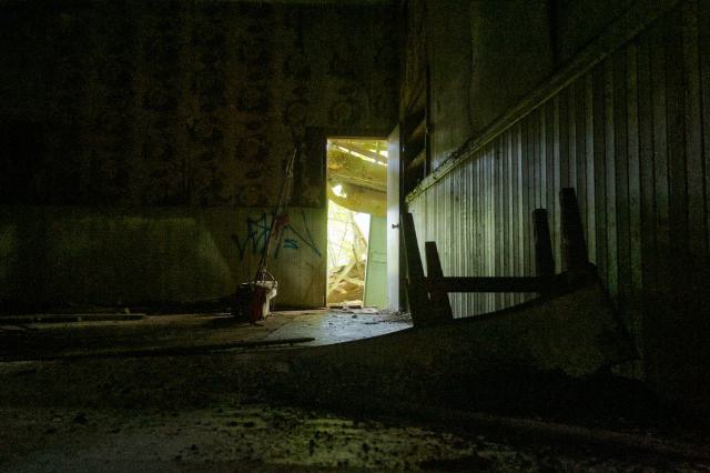 Photo taken from the floor, destroyed bathroom at the door.